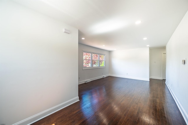 empty room with recessed lighting, baseboards, dark wood-style floors, and visible vents