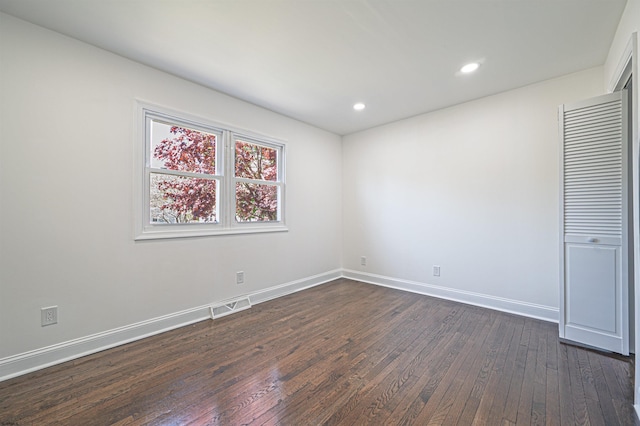 unfurnished bedroom featuring recessed lighting, baseboards, dark wood finished floors, and visible vents