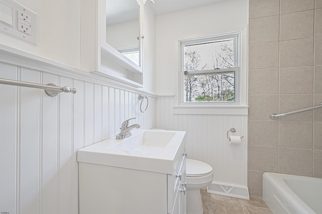 full bathroom with visible vents, tile patterned flooring, wainscoting, vanity, and toilet