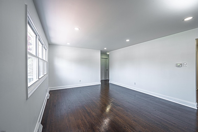 unfurnished room featuring recessed lighting, dark wood finished floors, and baseboards