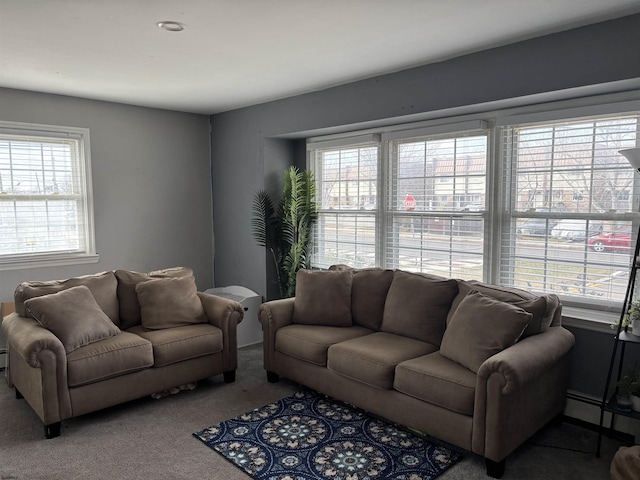 living area featuring carpet flooring, a baseboard heating unit, and plenty of natural light