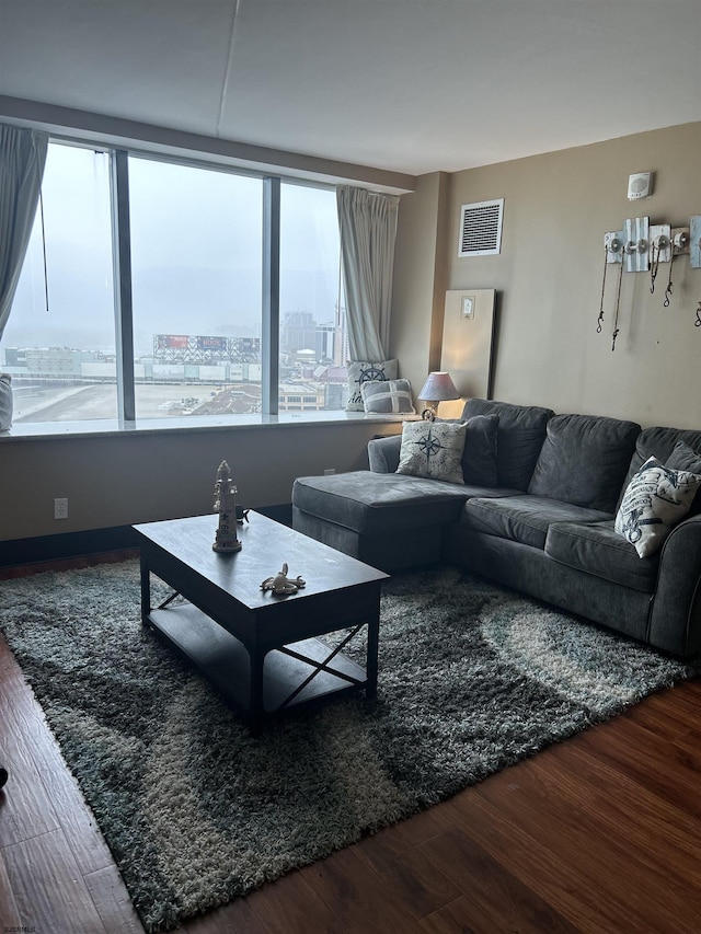 living room with visible vents, a city view, and wood finished floors