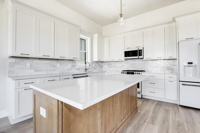 5513 W Ave Fl 1St, Ocean City, NJ 08226 - kitchen with light countertops, tasteful backsplash, white appliances, and light wood-style flooring
