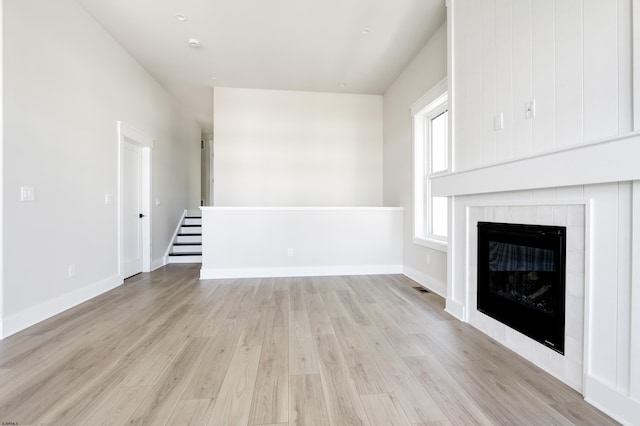 5513 W Ave Fl 1St, Ocean City, NJ 08226 - unfurnished living room with baseboards, light wood-style flooring, and a glass covered fireplace