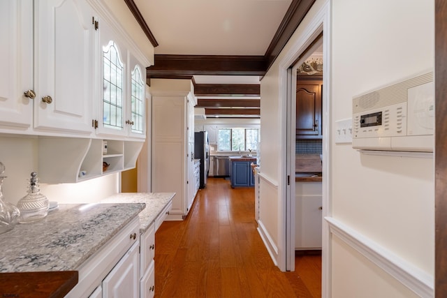 corridor with crown molding and light wood finished floors