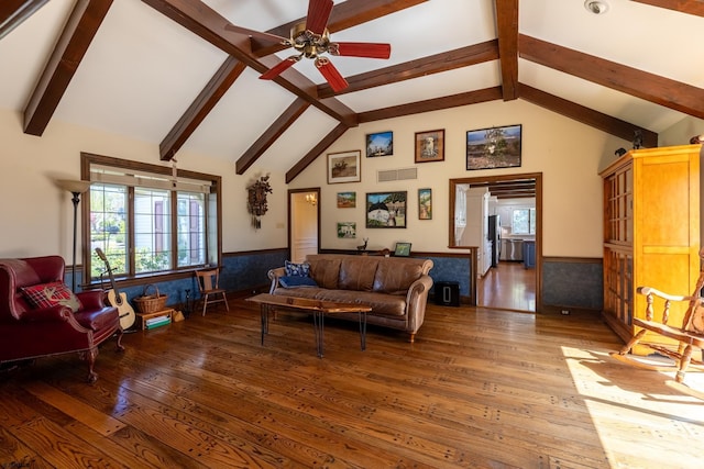 living area featuring wood-type flooring, a ceiling fan, and wainscoting