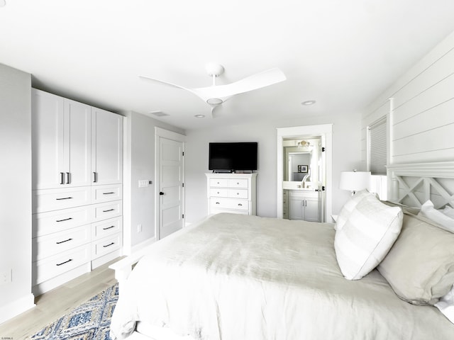 bedroom with a sink, ensuite bath, light wood-style flooring, recessed lighting, and a ceiling fan