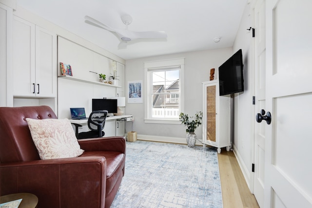 home office with baseboards, ceiling fan, and light wood finished floors