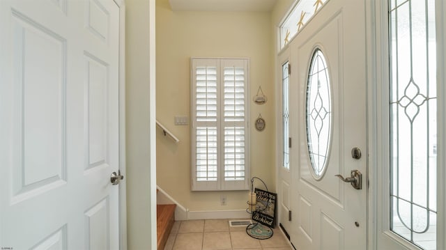 foyer featuring stairs, light tile patterned flooring, baseboards, and visible vents