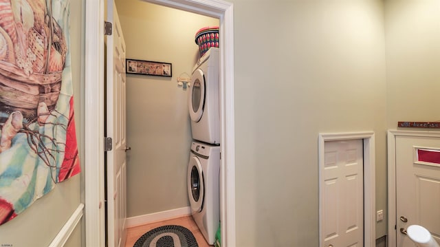 laundry room with laundry area, baseboards, and stacked washer and clothes dryer