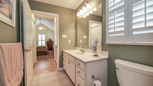 ensuite bathroom with tile patterned flooring, vanity, toilet, a ceiling fan, and vaulted ceiling