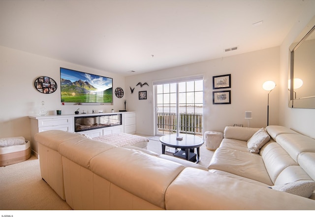 living room with baseboards, light carpet, and visible vents