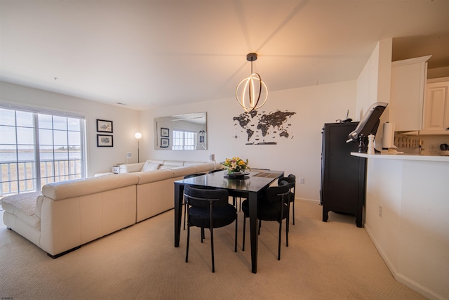 dining space featuring baseboards and light carpet