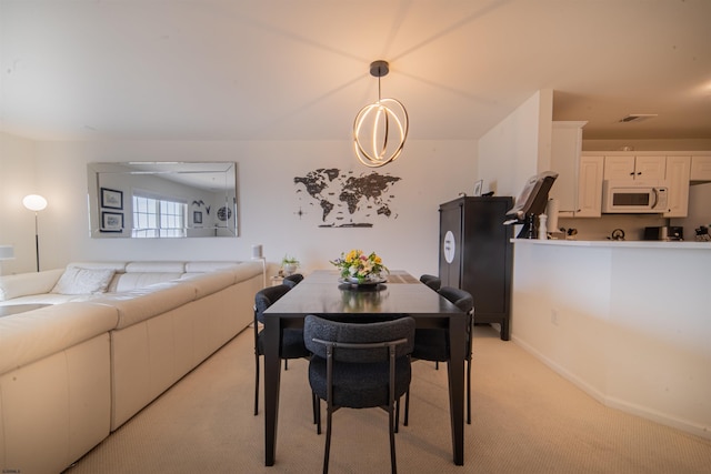 dining room with light colored carpet, baseboards, and visible vents