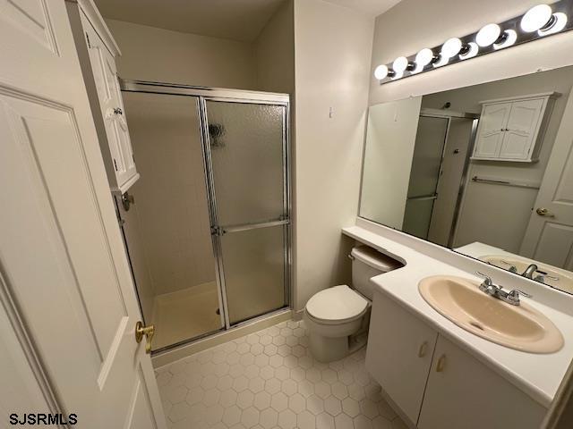 bathroom featuring vanity, toilet, and a stall shower