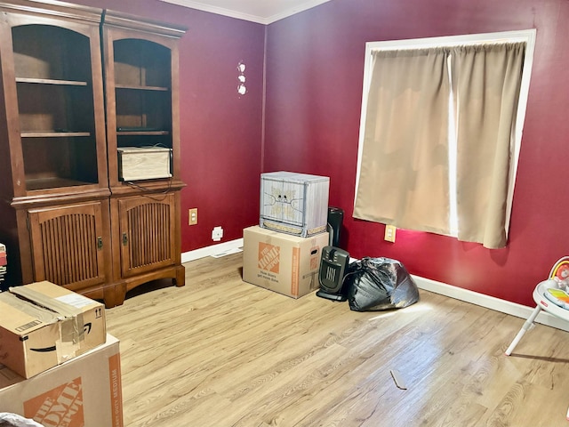misc room featuring crown molding, baseboards, and wood finished floors