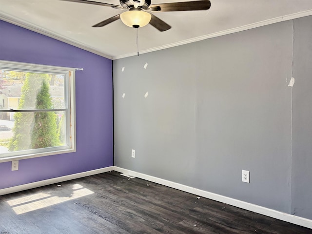 spare room with crown molding, dark wood finished floors, a ceiling fan, baseboards, and vaulted ceiling