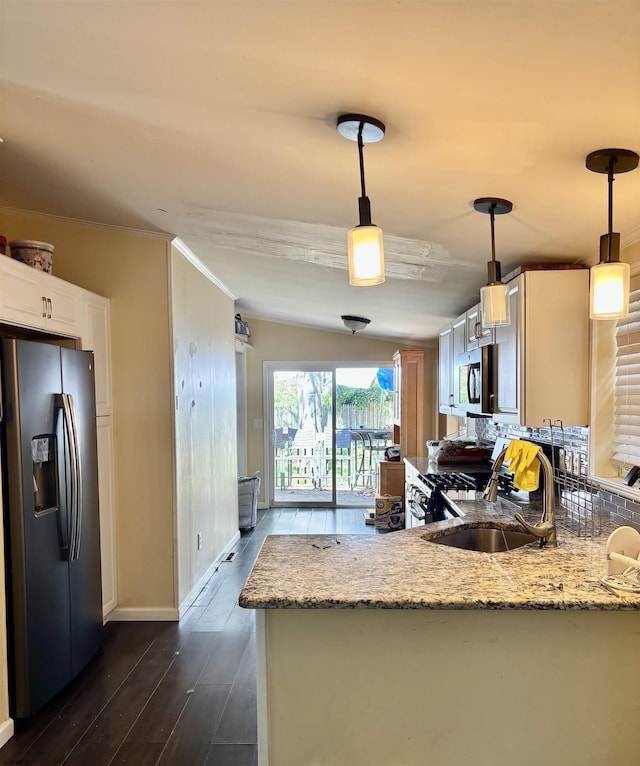 kitchen featuring light stone counters, appliances with stainless steel finishes, a sink, dark wood finished floors, and baseboards