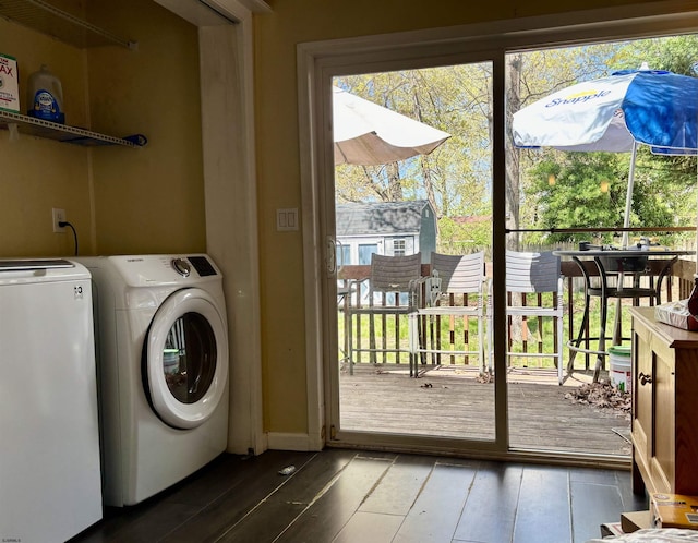 clothes washing area featuring wood-type flooring, separate washer and dryer, and laundry area