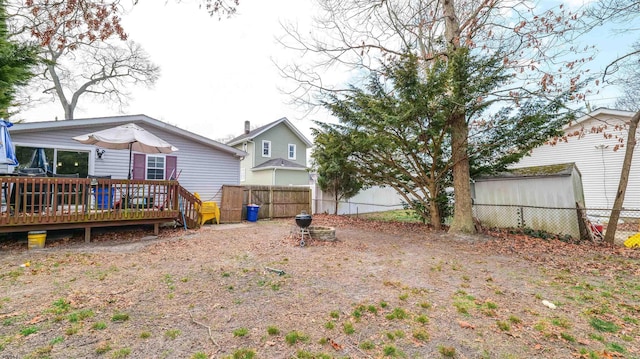 back of house featuring fence and a wooden deck