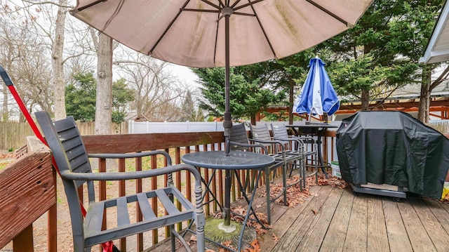 deck with a fenced backyard and a grill