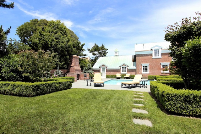 view of yard featuring a patio area, a fireplace, and an outdoor pool