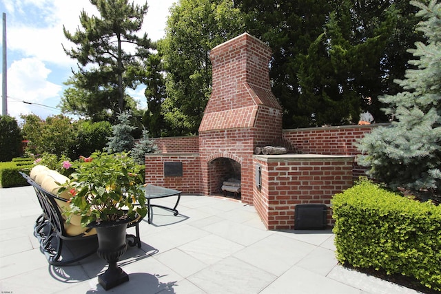 view of patio / terrace featuring an outdoor brick fireplace