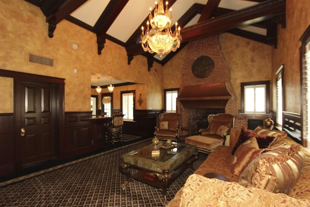 carpeted living area featuring an inviting chandelier, a wainscoted wall, high vaulted ceiling, and beamed ceiling