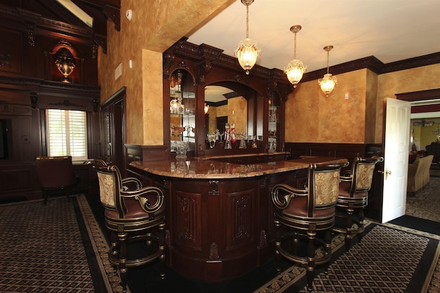 bar with a dry bar, a decorative wall, carpet floors, a wainscoted wall, and ornamental molding