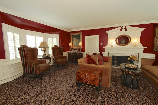 carpeted living area with ornamental molding, wainscoting, a decorative wall, and a premium fireplace