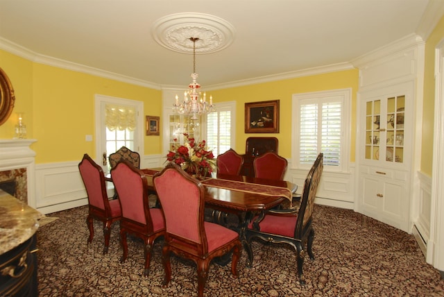 carpeted dining area featuring a chandelier, ornamental molding, a healthy amount of sunlight, and a decorative wall