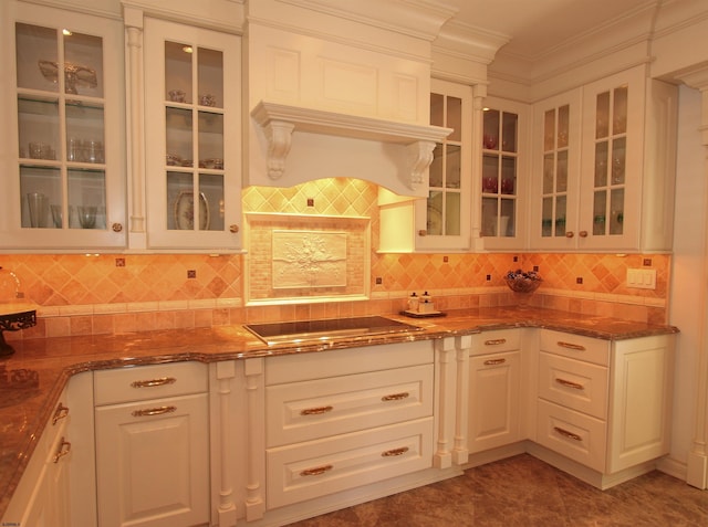 kitchen featuring glass insert cabinets, ornamental molding, dark stone countertops, and black electric cooktop