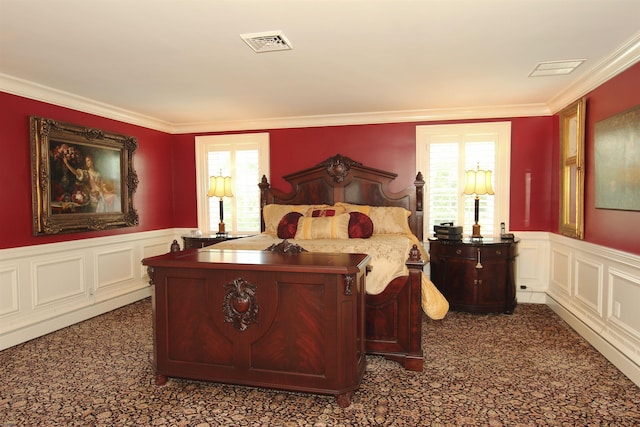 bedroom with visible vents, wainscoting, and multiple windows