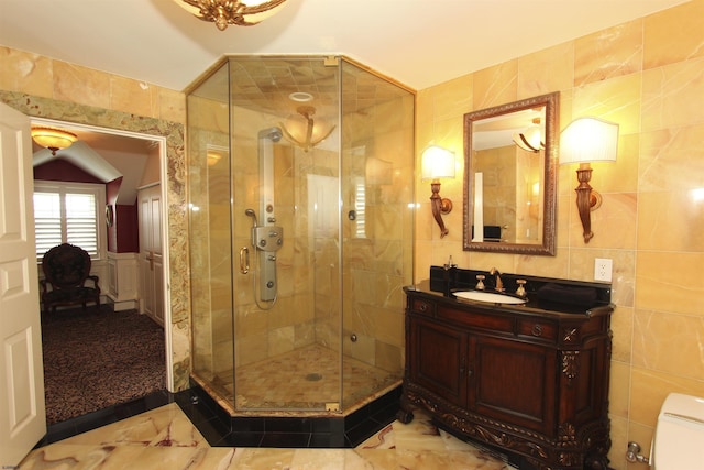 bathroom with vanity, a shower stall, and tile walls