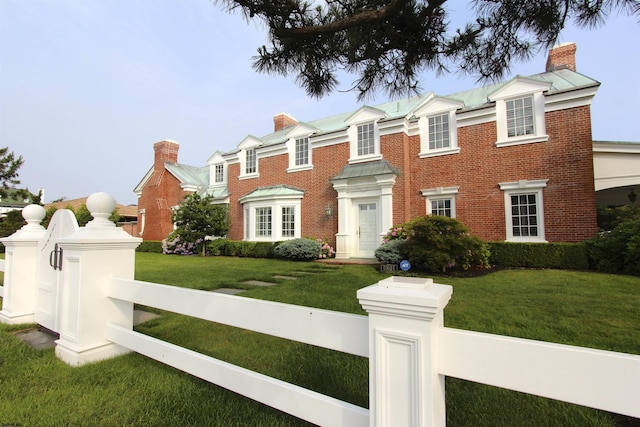 view of front of house with a front lawn, a fenced front yard, and a chimney