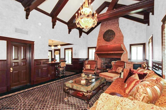 living room featuring a notable chandelier, high vaulted ceiling, a wainscoted wall, a wealth of natural light, and beamed ceiling