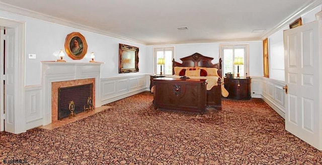 bedroom featuring visible vents, ornamental molding, and a decorative wall
