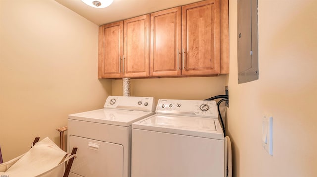 washroom with separate washer and dryer, cabinet space, and electric panel