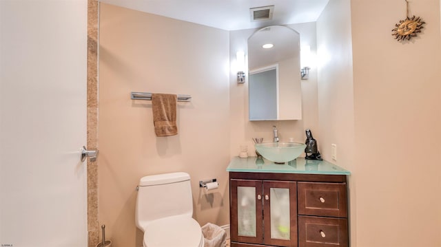 bathroom with vanity, toilet, and visible vents