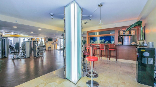 interior space featuring recessed lighting, tile patterned floors, decorative columns, and a dry bar