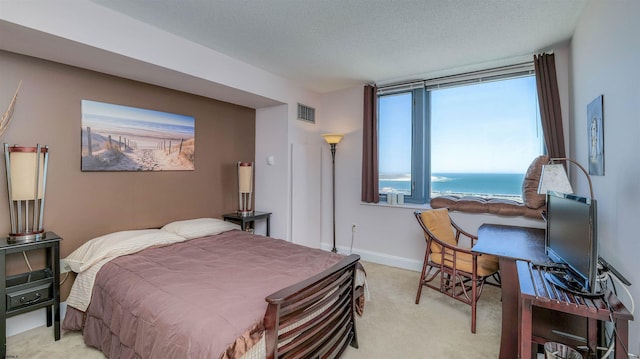 bedroom with visible vents, a textured ceiling, baseboards, and light colored carpet