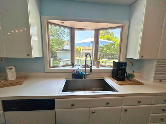 306 W Revere Ave, Northfield, NJ 08225 - kitchen featuring white dishwasher, a sink, white cabinetry, and healthy amount of natural light