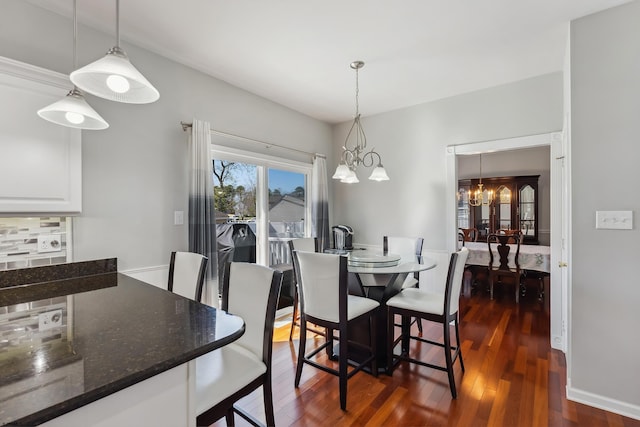 dining area featuring an inviting chandelier and dark wood finished floors