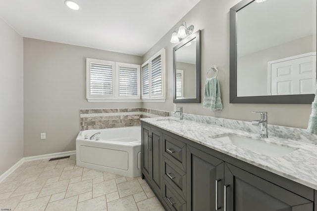 full bath featuring double vanity, baseboards, a sink, and a bath