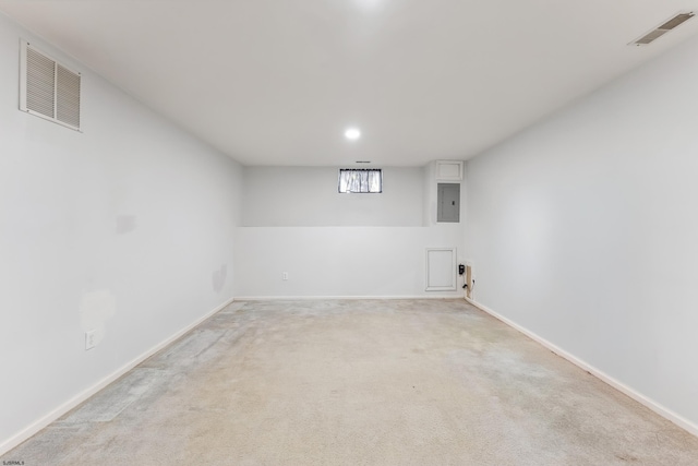 below grade area with baseboards, visible vents, light carpet, and electric panel