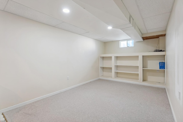 below grade area featuring carpet flooring, recessed lighting, baseboards, and a paneled ceiling