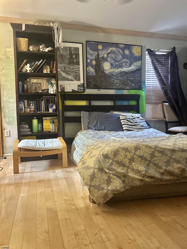 bedroom with ornamental molding and hardwood / wood-style floors