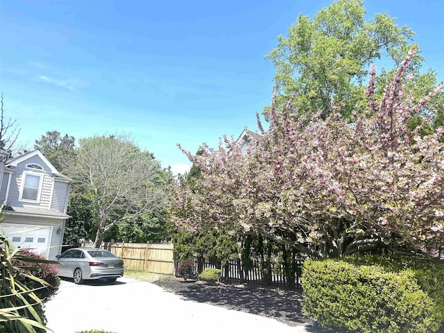 exterior space featuring fence, driveway, and a garage