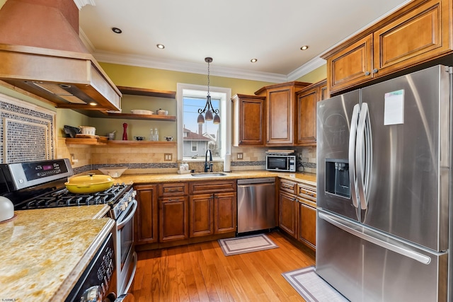 kitchen featuring premium range hood, brown cabinets, a sink, light wood finished floors, and stainless steel appliances