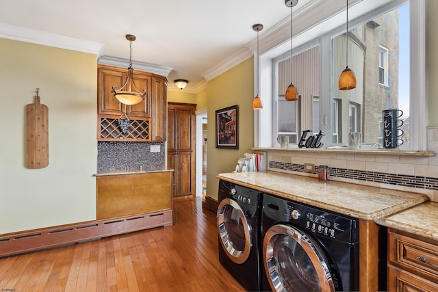 washroom with laundry area, baseboard heating, light wood finished floors, baseboards, and ornamental molding